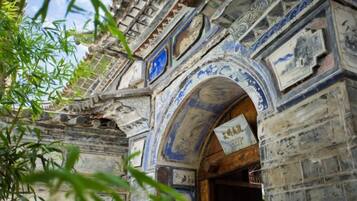 An arched entrance with intricate carvings and a signboard.