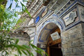 An arched entrance with intricate carvings and a signboard. - Manyue Wangjiayuan Hostel (Dali City)