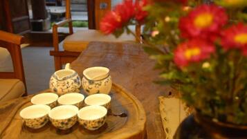 A wooden table with ceramic cups and a vase with flowers.