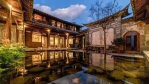 A traditional courtyard with a reflective water feature, wooden buildings, and stone walls. - Manyue Wangjiayuan Hostel (Dali City)