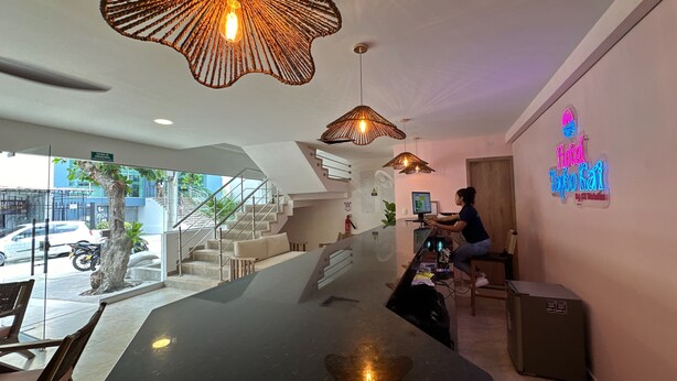 A modern hotel lobby with a reception desk, a staircase, and a neon sign. - Hotel Taybo Kai By St Hoteles (Santa Marta)