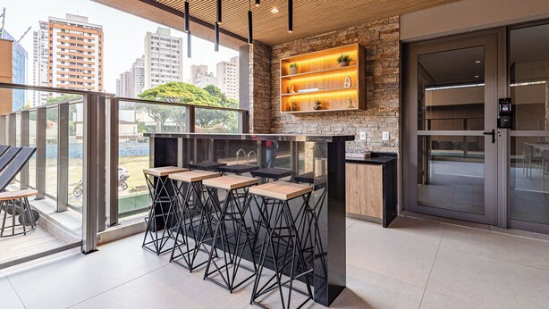 Eine moderne Bar mit Glasgeländer, Blick auf die Stadt und Holzboden.