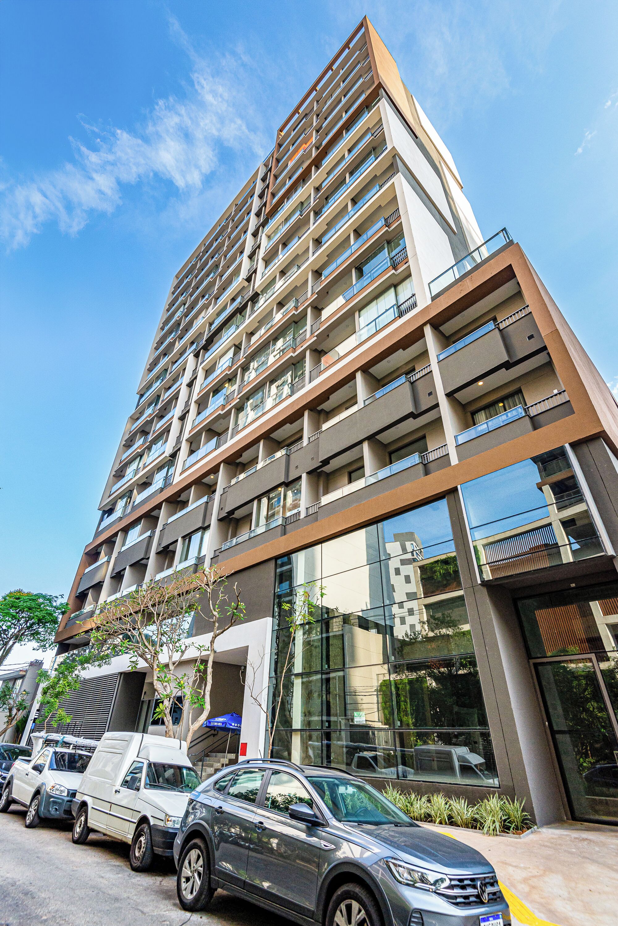 Un immeuble à plusieurs étages, doté d’une architecture moderne, avec des balcons et de grandes fenêtres.