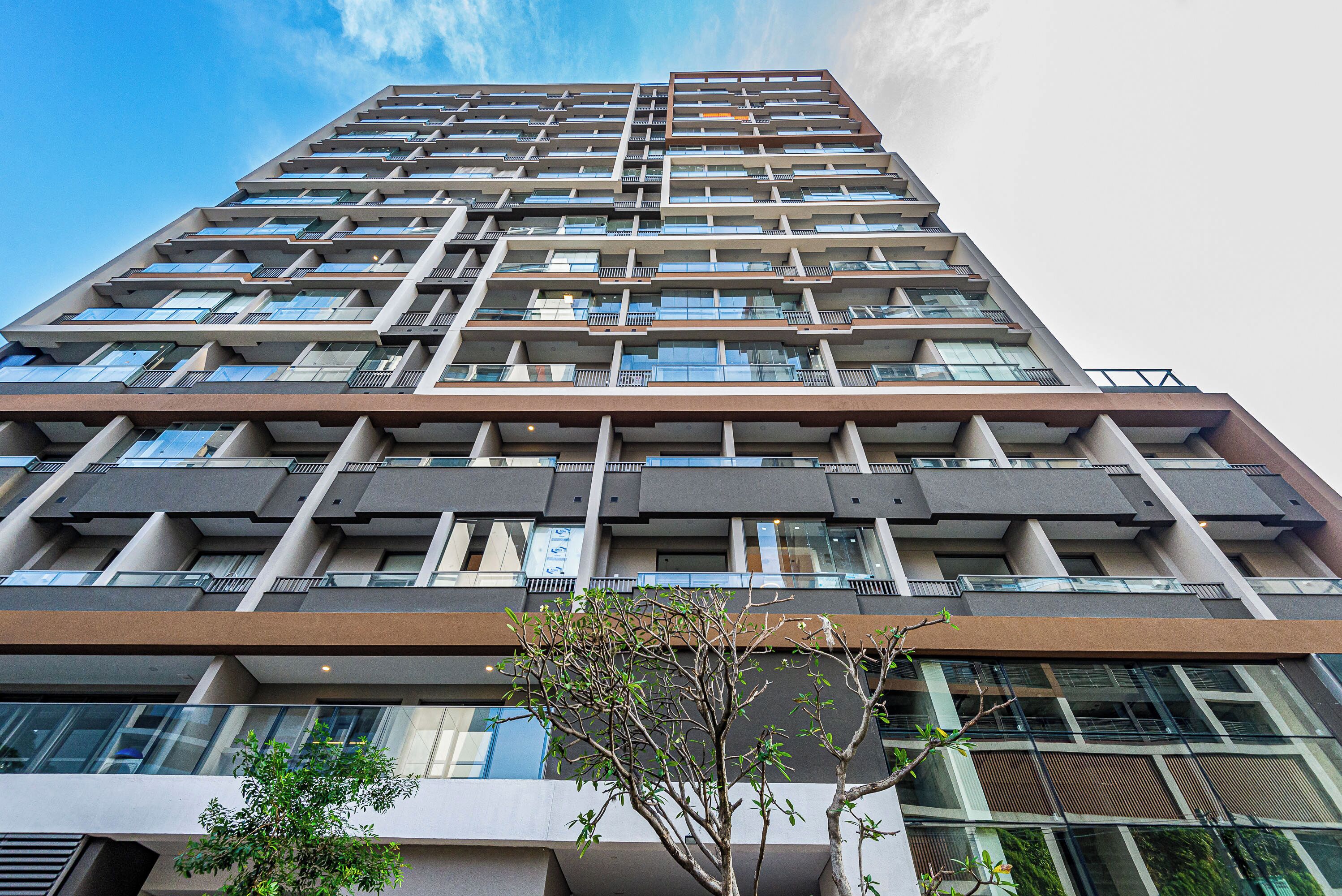 A high-rise building with multiple balconies and large windows.