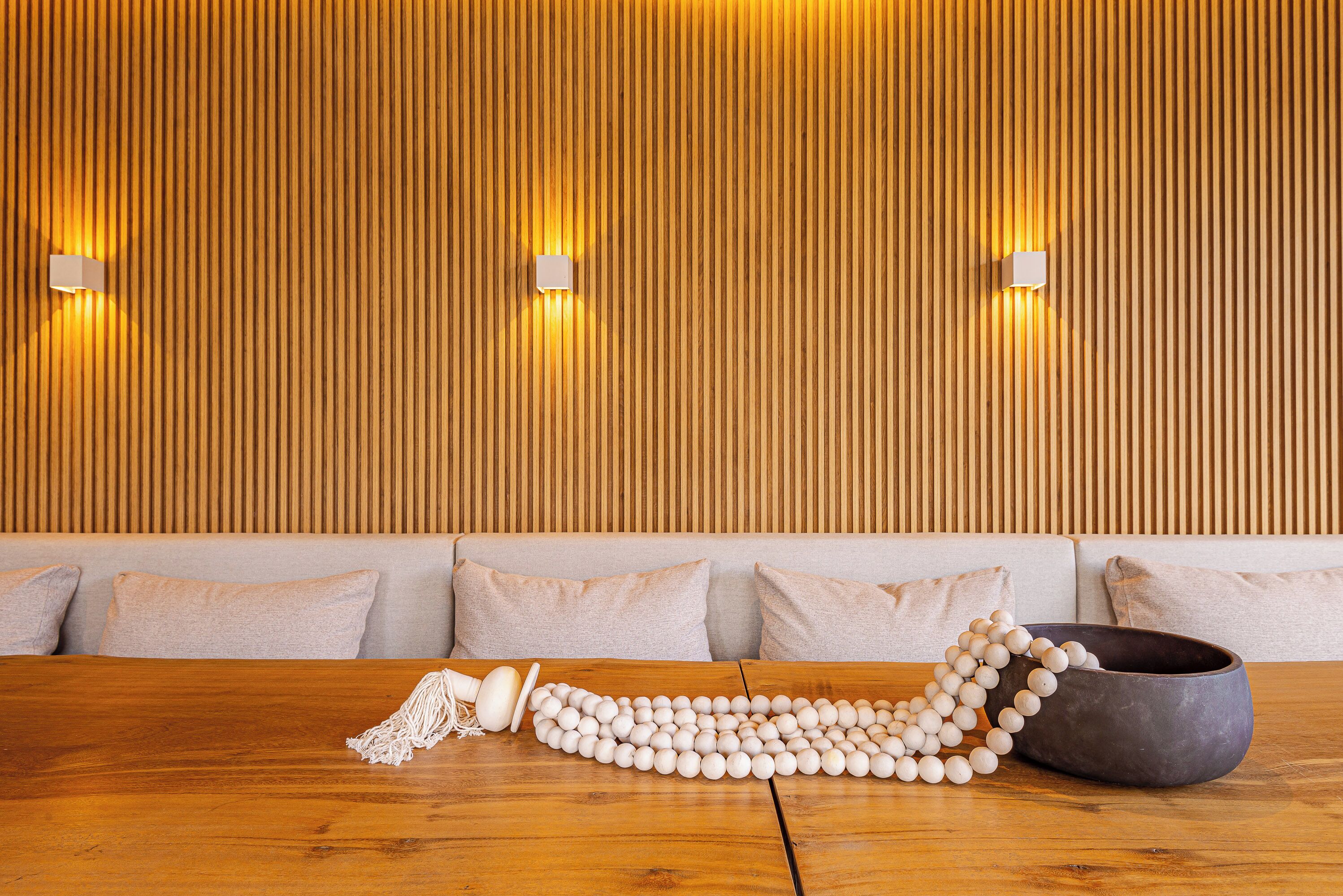 A wooden wall with vertical slats and two wall-mounted lights.