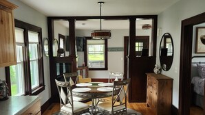 Un coin repas avec une table ronde et des chaises, des meubles en bois et un tapis.