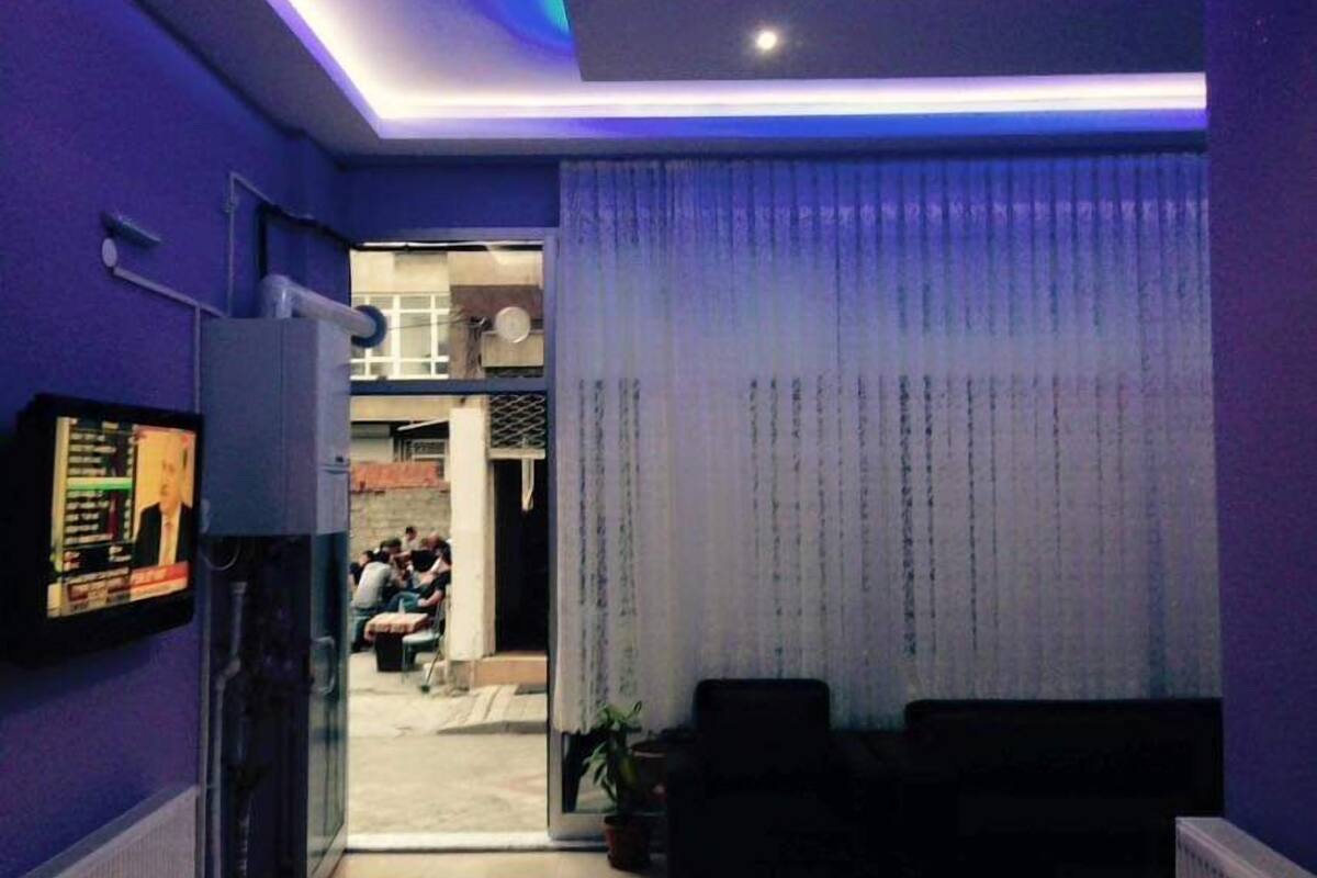 A living room with a TV, a sofa, and a view into the adjacent room.