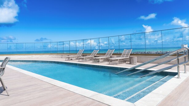 A pool with lounge chairs and a view of the beach. - Roomo Transamerica Recife Parque do Cais (Recife)