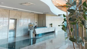 A spacious lobby with a curved ceiling, a reception desk, and a large plant. - Roomo Transamerica Recife Parque do Cais (Recife)