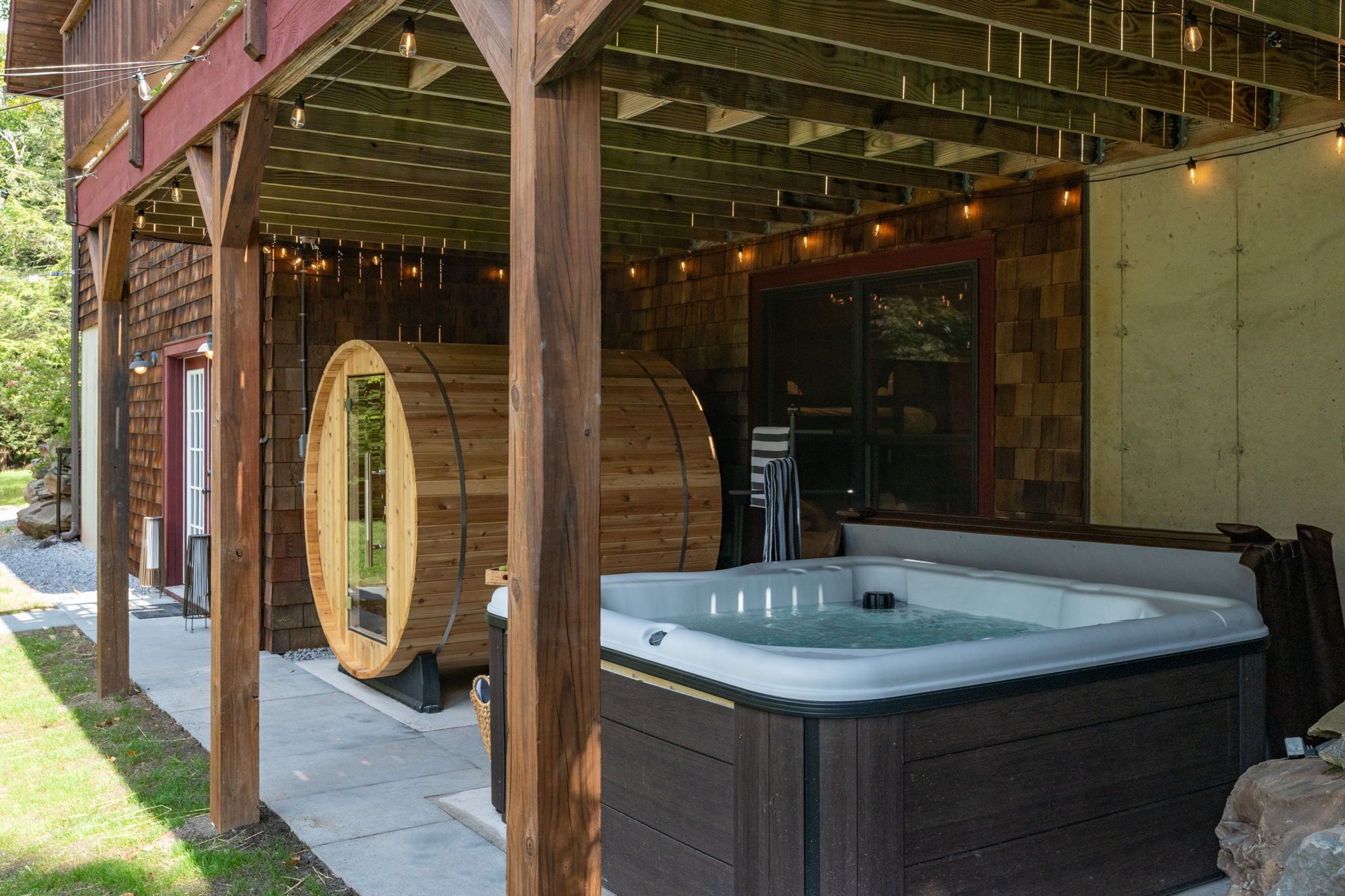 Un espace de détente en bois comprenant un jacuzzi et des sièges en forme de tonneau.