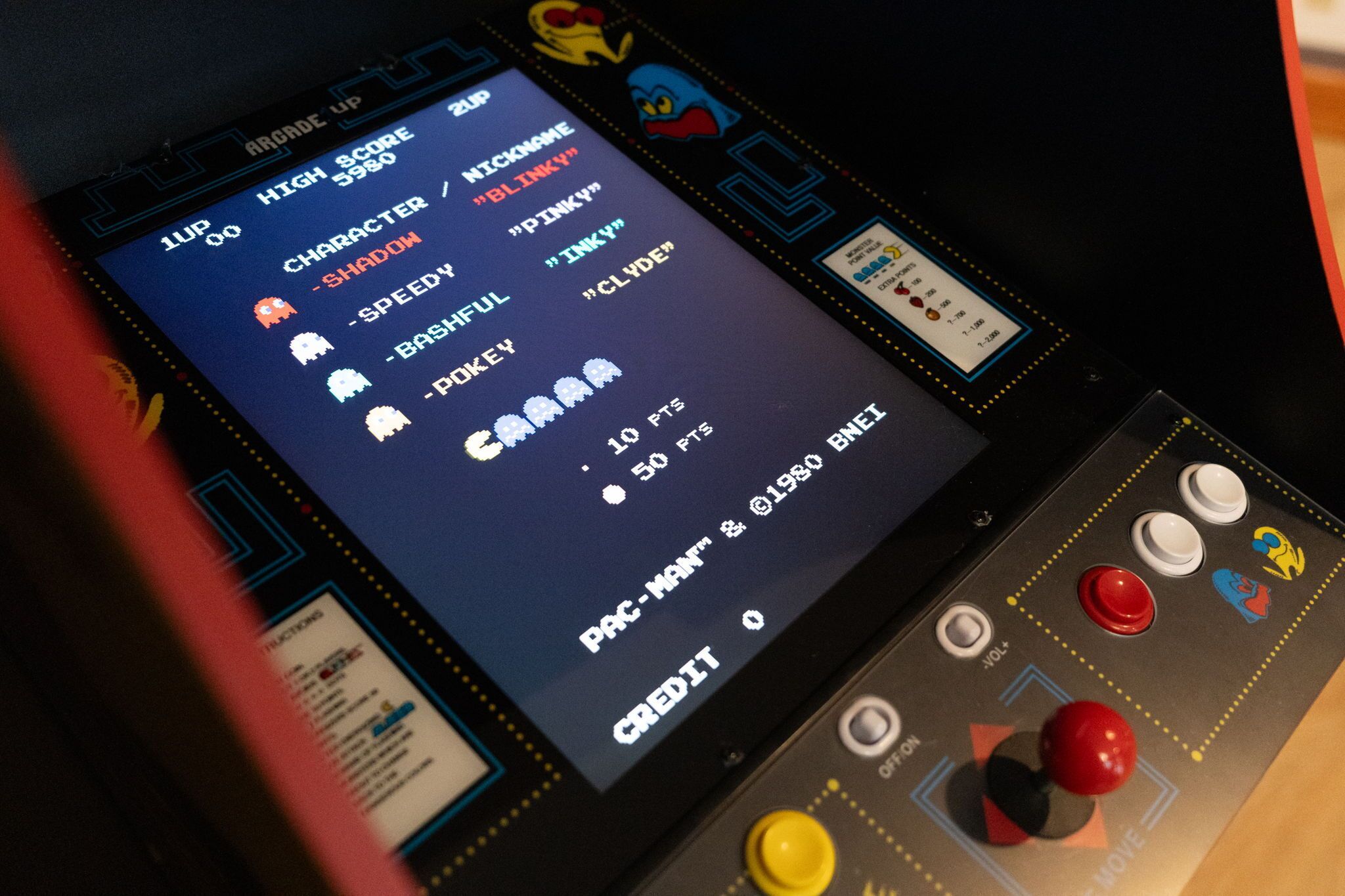 Ein altes Arcade-Spiel mit einem Bildschirm, der Charakter Namen zeigt, und einem Joysticks Bedienfeld.