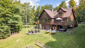 A large wooden cabin with a deck and outdoor seating area. - Luxury Chalet, Firepit, Sauna, Pet Friendly, 5 mins to Windham Mtn resort (Windham)