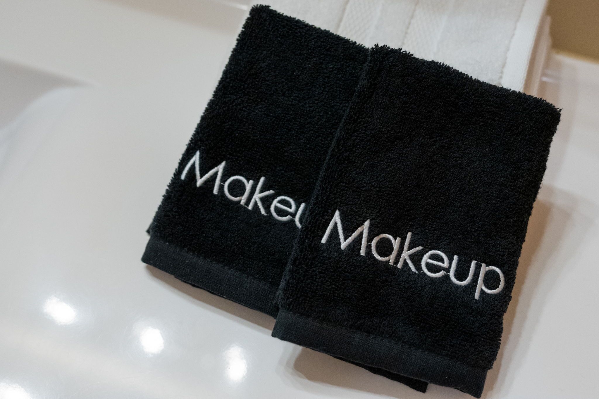 Two black towels with "Makeup" embroidered on them.