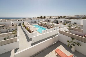 A rooftop pool area with lounge chairs and a clear view of the sea. - Nazaret Beach (Arrecife)