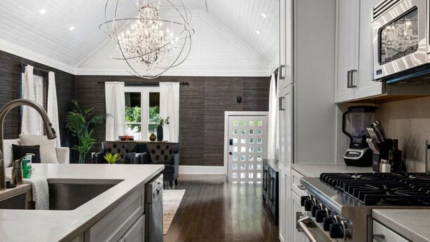 A modern kitchen with a central island, stainless steel appliances, and a chandelier. - Luxe Studio w/ King Bed + Sofa | Walk to OSU/Bars (Columbus)
