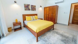 Ein Schlafzimmer mit einem hölzernen Bett, einem Nachttisch, einem Kleiderschrank und Bildern an der Wand.