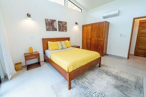 A bedroom with a wooden bed, a nightstand, a wardrobe, and artwork on the wall.
