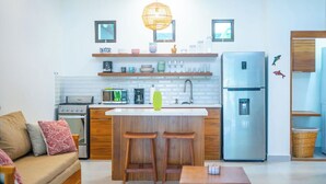 A compact kitchen with a central island, a refrigerator, a stove, and a sink. - Bright and Tropical Casa Mar, Playa Pelada, Nosara (NICOYA)
