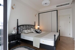 Ein Schlafzimmer mit Bett, Nachttisch, Lampe und Kleiderschrank.