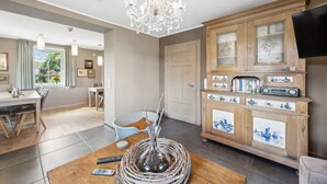 A living room with a wooden cabinet, a chandelier, and a dining area with a table and chairs. - Amazing home in Feuerscheid (Feuerscheid)