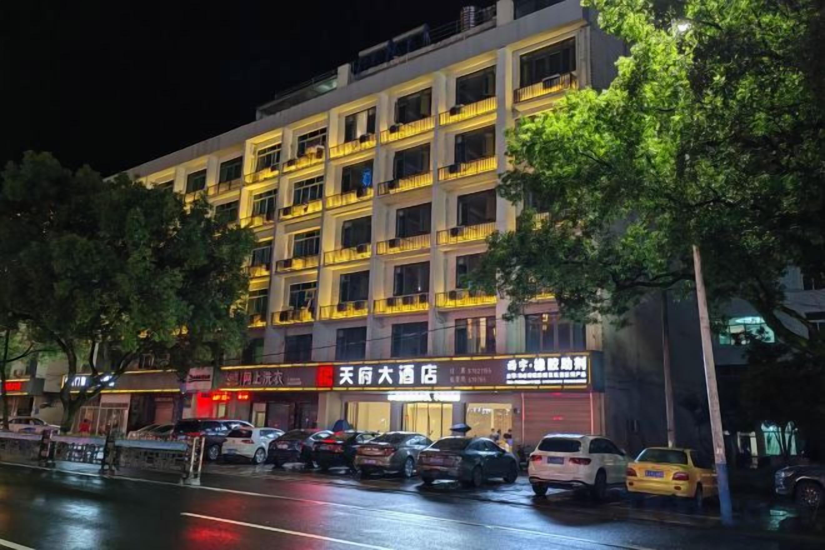 A multi-story building with several ground-floor shops and a parking area.
