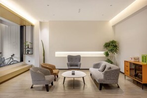 A modern living room with a sofa, armchairs, a coffee table, and a sideboard. - Tianfu Hotel (Xianju)