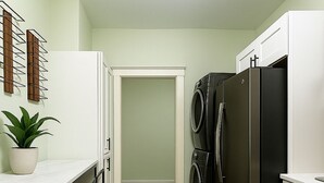 A compact kitchen with a dining area, a washing machine, and a refrigerator.