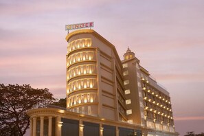 A hotel with a curved facade, multiple balconies, and a prominent sign at the top. - Ginger Kochi, Kalamassery (Kanayannur)