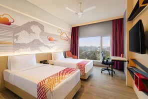 A hotel room with two beds, a desk, a chair, a TV, and a large window with a city view. - Ginger Kochi, Kalamassery (Kanayannur)