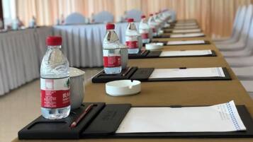 A conference room with tables set up with water bottles, notepads, and pens.