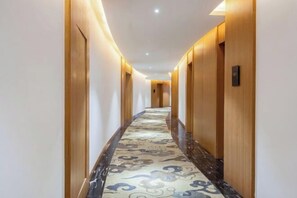 A long, narrow hallway with wooden doors and a patterned carpet. - Lanjiang Hotel (Lanxi)