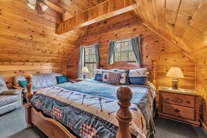 Quarto de cabana de madeira com cama, mesa de cabeceira e janela com cortinas.