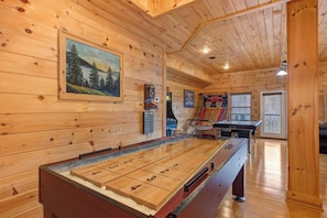 A wooden-floored room with a foosball table, a pool table, and a painting on the wall. - Cabin w/ Mountain Views, Hot Tub & Game Room! (Sevierville)