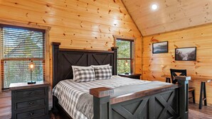 A wooden cabin bedroom with a bed, nightstands, and a desk. - Modern Cabin w/ Pool, Hot Tub, Games & More! (Sevierville)