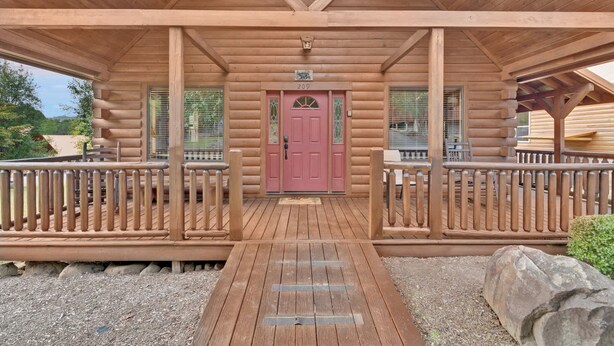 A log cabin with a wooden porch, a red door, and a number '209' above it.