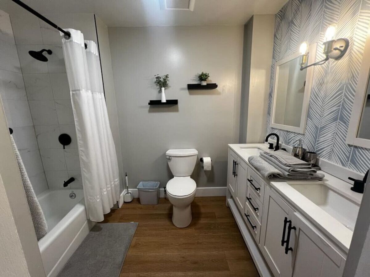 Une salle de bain avec douche, toilettes et lavabo.