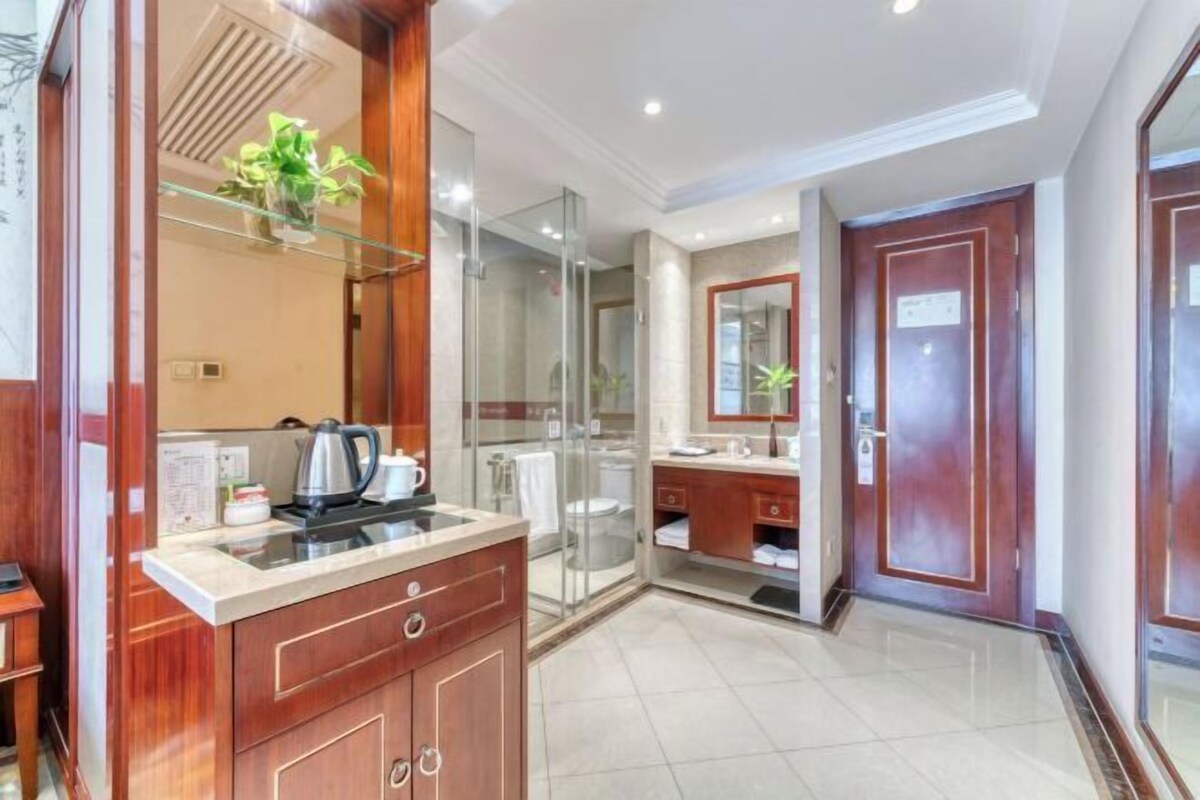 A modern bathroom with a glass shower enclosure, a vanity with a mirror, and a sink.