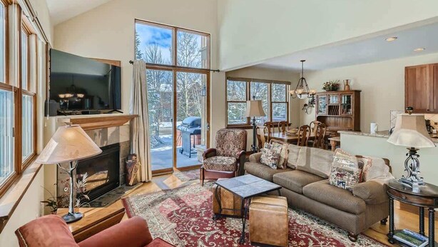 A spacious living room with a fireplace, large windows, and a cozy seating area. - Beautiful Unit in Quiet Area w/ Shuttle to Slopes (Breckenridge)
