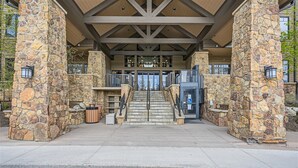 A stone-clad entrance with a staircase leading to a building, outdoor seating, and a wheelchair-accessible entrance. - Best Mtn View-Ski In/Ski Out & Gondola to Downtown (Breckenridge)