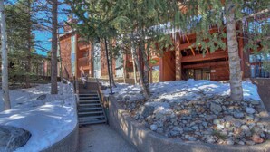 A building with a stone foundation, wooden exterior, and a staircase leading to a door. - Tons of Amenities! | Ski In Ski Out! (Breckenridge)