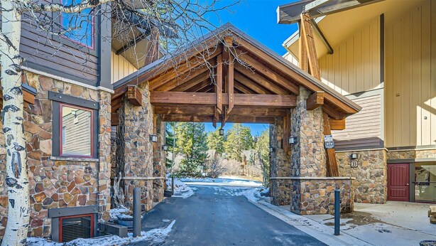 Un bâtiment en pierre avec une porte en bois et un sol recouvert de neige.