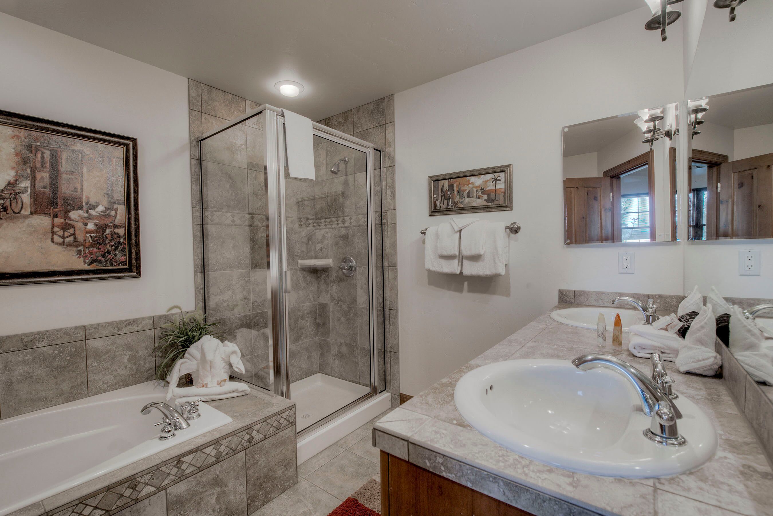 A modern bathroom with a glass-enclosed shower, a large sink, and a mirror.
