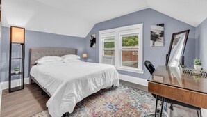A bedroom with a bed, a desk, a window, and a view of the outside. - Quaint 2BR in Historical Little Italy
 (Cleveland)