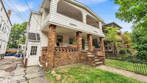 A two-story house with a porch, brick columns, and a front door labeled "2236". - Quaint 2BR in Historical Little Italy
 (Cleveland)