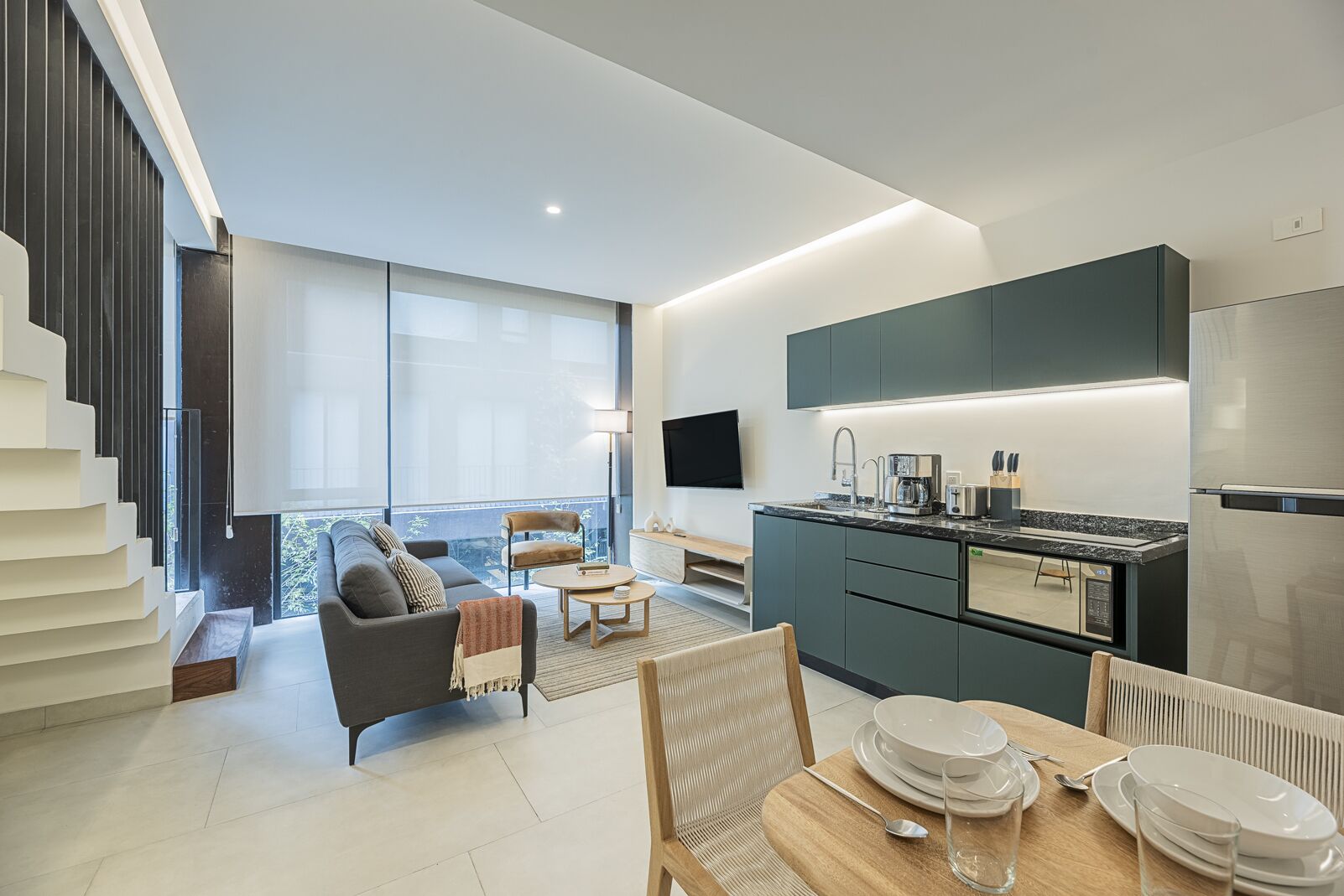 A modern apartment with a living area, kitchen, and dining space.
