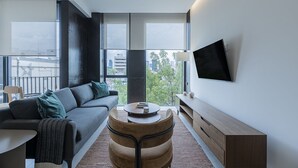 Een moderne woonkamer met een bank, salontafel en televisie.