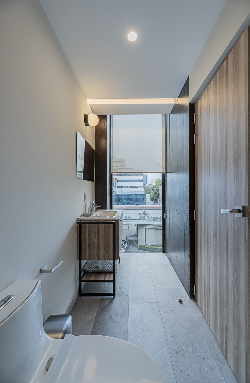 Un baño moderno con una bañera grande, un lavabo con espejo y un mueble de tocador de madera.