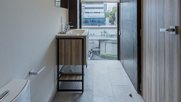 Une salle de bain moderne avec une grande baignoire, un lavabo avec un miroir et un meuble-lavabo en bois.