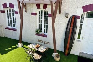 Enjoy outdoor dining or relaxation on the patio, with a surfboard nearby, in this charming single-story retreat.
