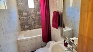 Ein Badezimmer mit Badewanne, Toilette und Waschbecken.